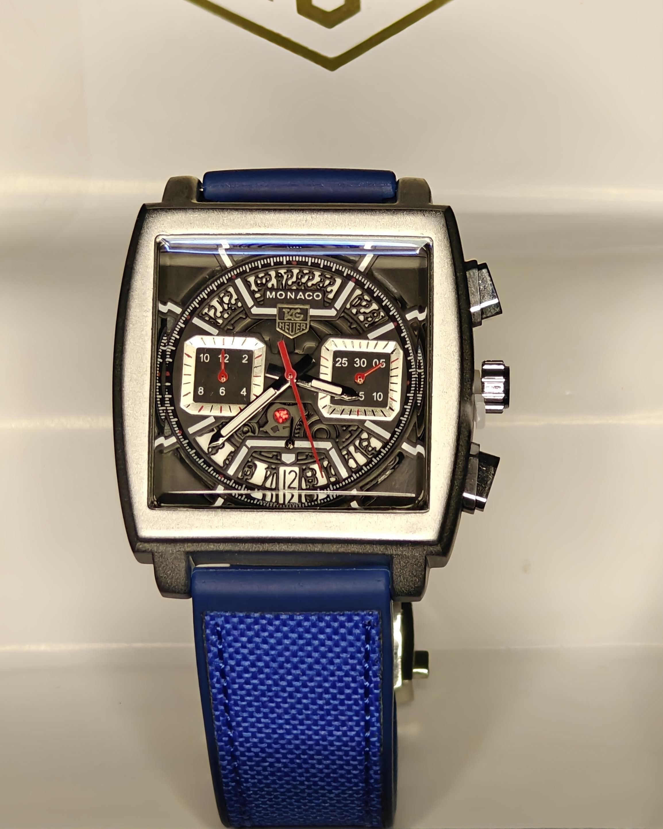 Watch with blue strap and detailed face on a light gray background